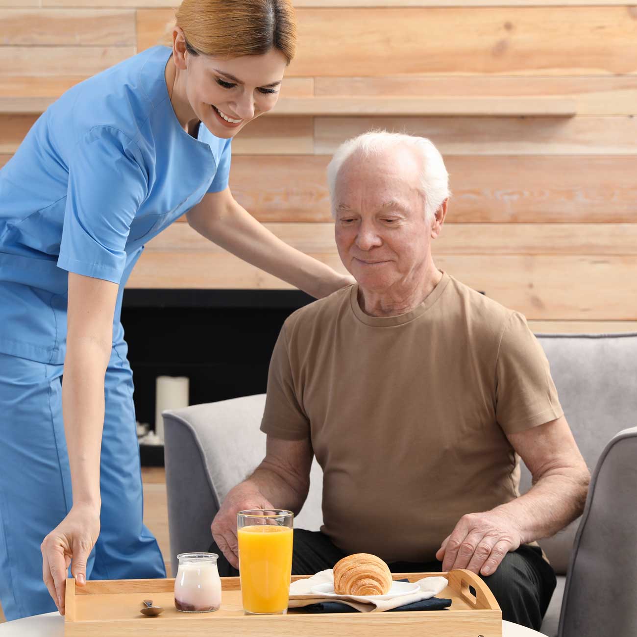 Home health aide serving a meal to a senior patient.